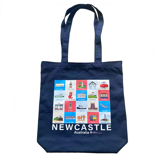 A navy blue canvas tote bag featuring a colorful grid of Newcastle, Australia travel icons and the text 'NEWCASTLE Australia' printed in white. The bag has two shoulder straps and is photographed against a plain white background. Includes Nobbys, Cathedral, Newcastle Baths, Merewether Baths, Obelisk, Tug Boat, Customs House, Anzac Walk